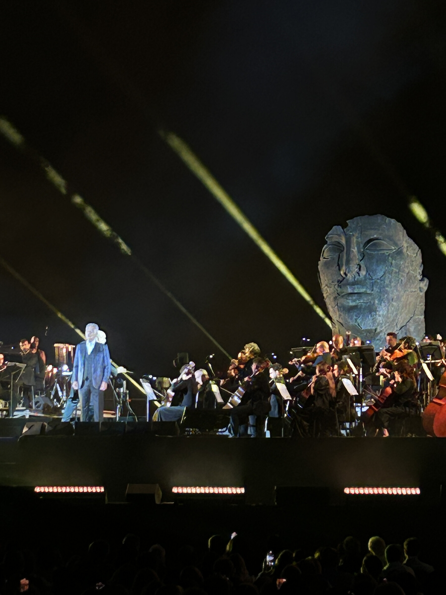 Andrea Bocelli performing with an orchestra at Teatro del Silenzio in Lajatico